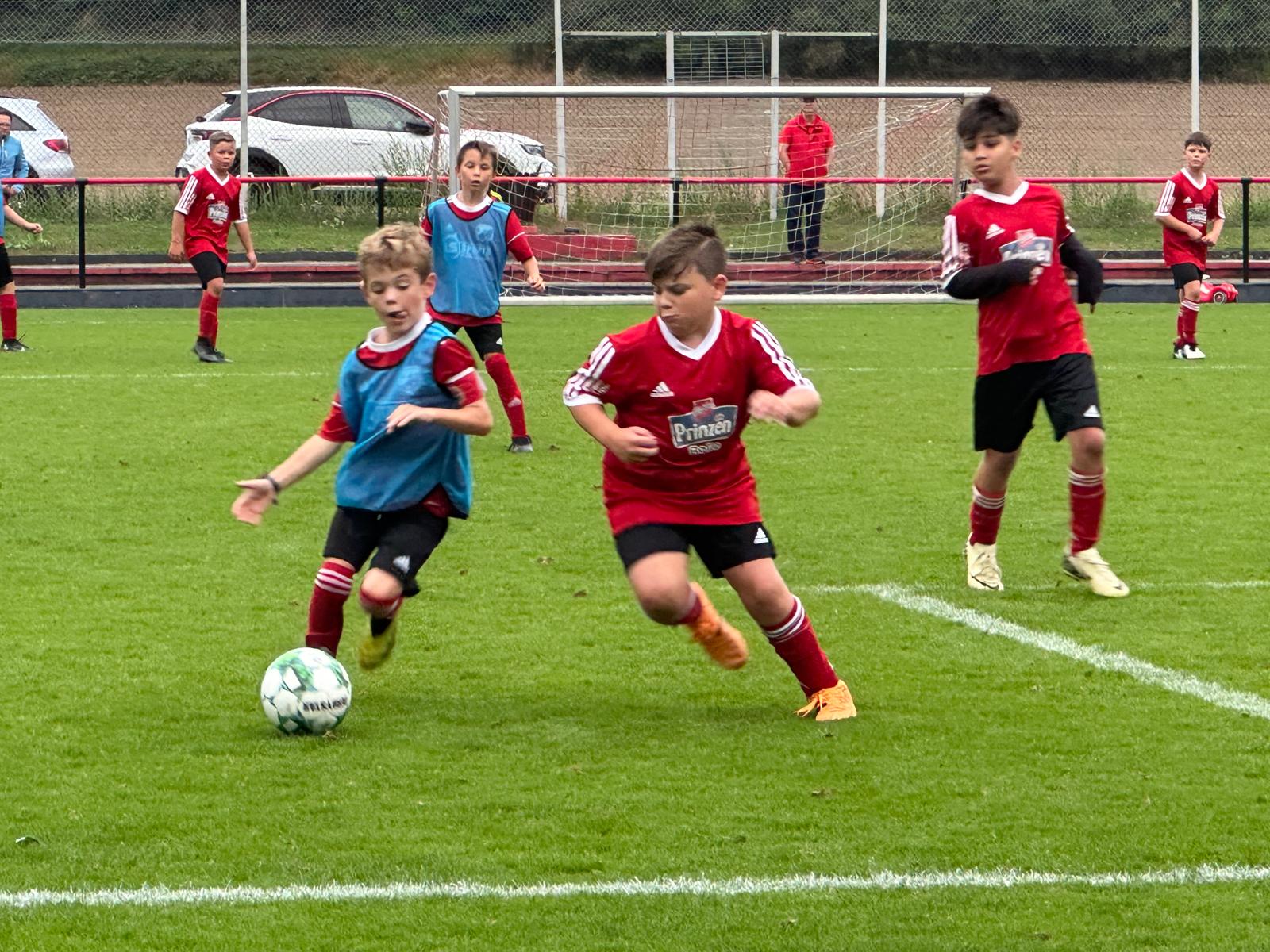Jugendfußball: Spieler im roten Trikot im Zweikampf um den Ball